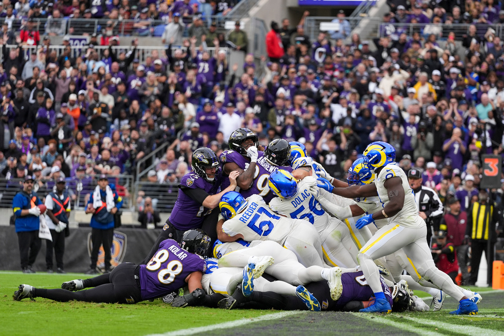 Baltimore Ravens tight end Mark Andrews, center left, and teammates attempt a tush push play against the Los Angeles Rams during the first half of an NFL football game Sunday, Oct. 12, 2025, in Baltimore. (AP Photo/Stephanie Scarbrough)
