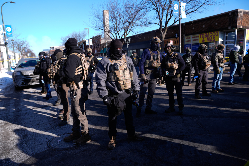 Federal agents stand near the site of a shooting Saturday, Jan. 24, 2026, in Minneapolis. (AP Photo/Abbie Parr)