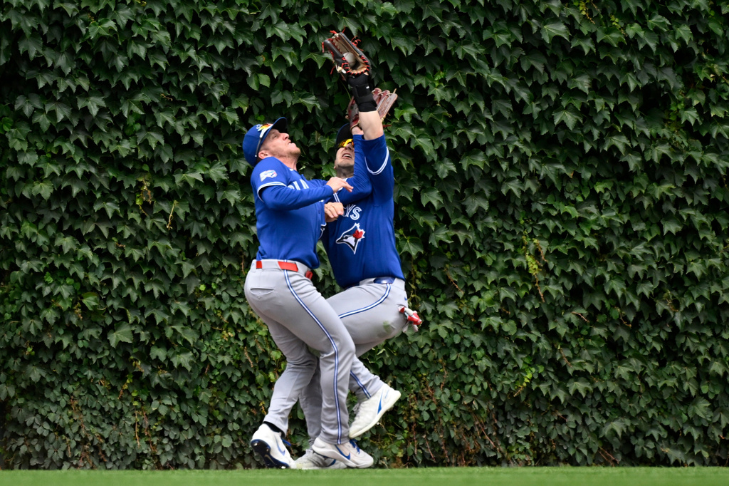 Toronto Blue Jays right fielder Myles Straw, left, and center fielder Dulton Varsho collide as Varsho' makes the catch on a fly ball hit by Chicago Cubs' Miguel Amaya during the fourth inning of a baseball game, Saturday, June 20, 2026, in Chicago. (AP Photo/Matt Marton)