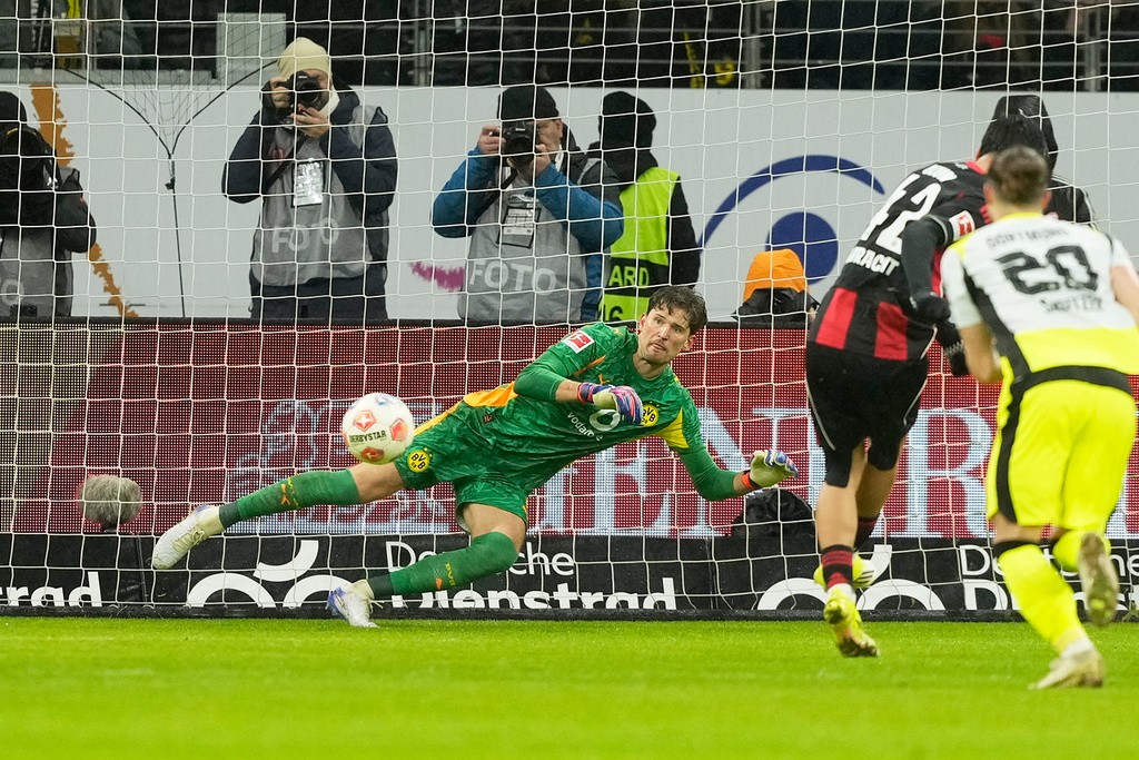 Frankfurt's Can Uzun, second right, scores his side's opening goal past Dortmund's goalkeeper Gregor Kobel during the Bundesliga soccer match between Eintracht Frankfurt and Borussia Dortmund in Frankfurt, Germany, Friday, Jan. 9, 2026. (AP Photo/Michael Probst)