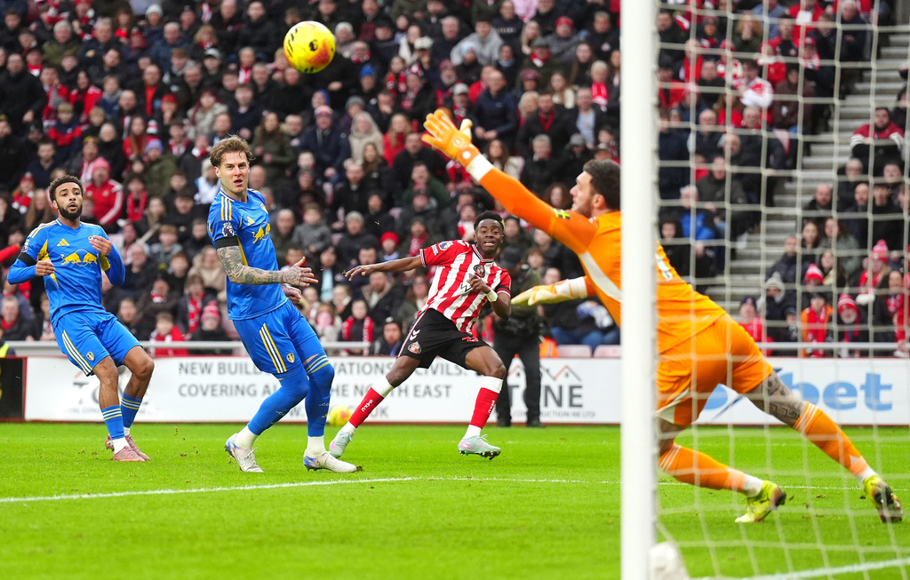 Sunderland's Simon Adingra, center, scores their side's first goal of the game past Leeds United goalkeeper Lucas Perri during the English Premier League soccer match in Sunderland, England, Sunday, Dec. 28, 2025. (Owen Humphreys/PA via AP)