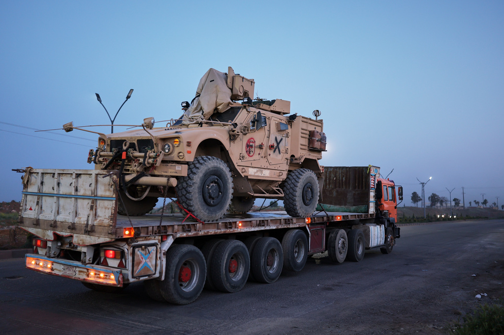 A U.S. military vehicle is transported on a truck as part of a convoy withdrawing from Qasrak base in northeastern Hasakah province toward the Jordanian border near Daraa, Syria, Thursday, April 16, 2026. (AP Photo/Ghaith Alsayed)