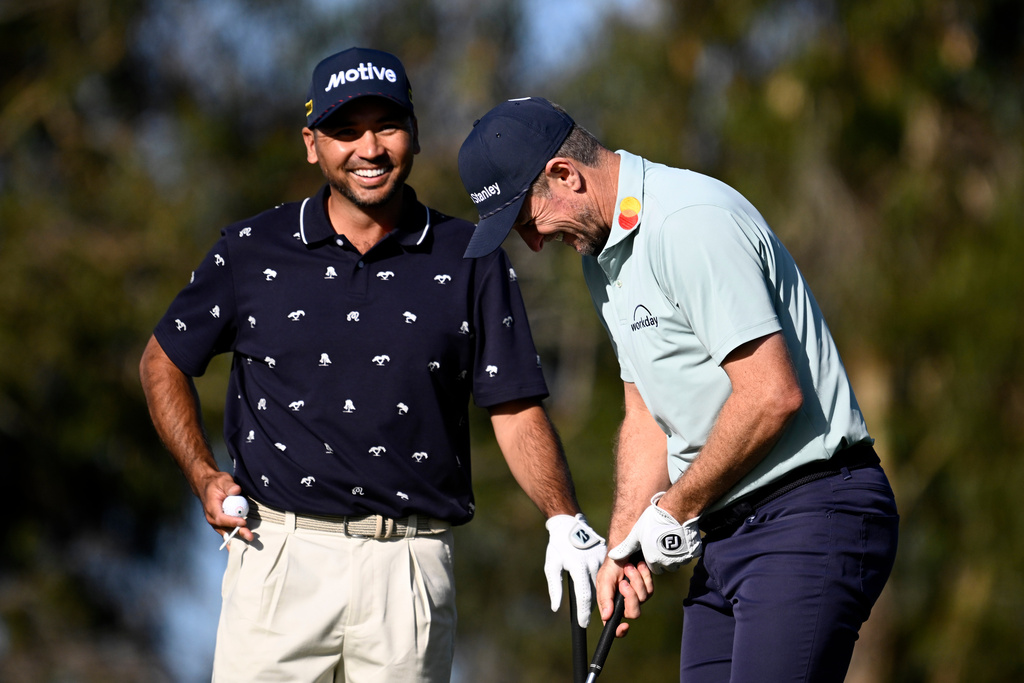 Justin Rose, right, of England, and Jason Day, of Australia, smile after Rose hit his tee shot on the ninth hole on the North Course at Torrey Pines during the first round of the Farmers Insurance Open golf tournament Thursday, Jan. 29, 2026, in San Diego. (AP Photo/Denis Poroy)