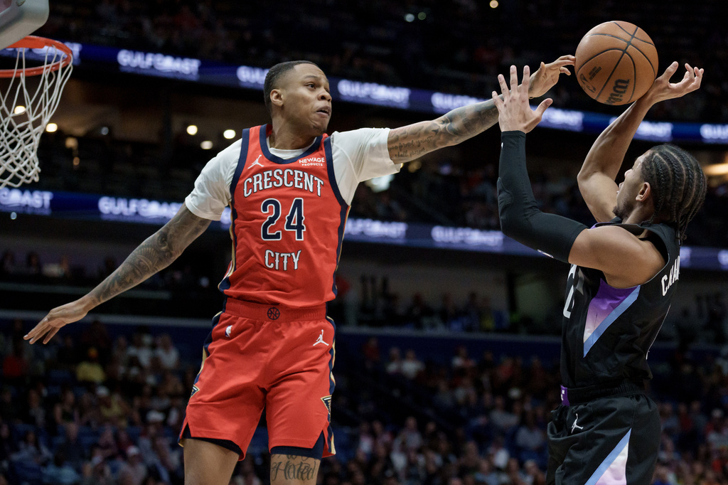 New Orleans Pelicans guard Jordan Hawkins (24) blocks the shot of Utah Jazz guard Kennedy Chandler (0) during the first half of an NBA basketball game in New Orleans, Tuesday, April 7, 2026. (AP Photo/Matthew Hinton)