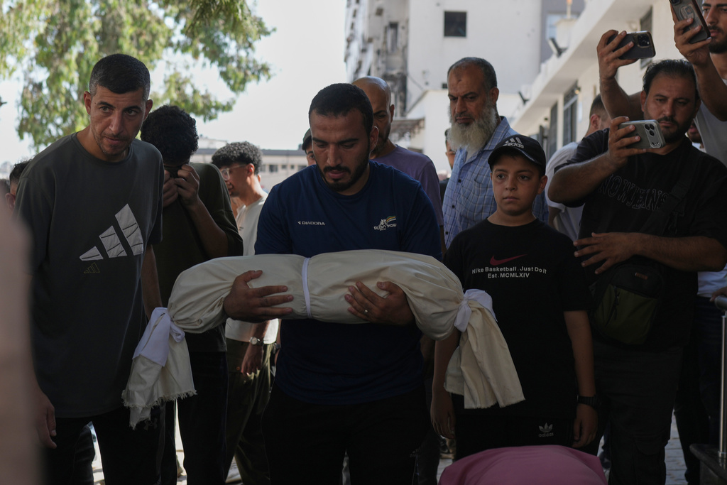 Mourners carry the body of Palestinian child Azzam Abu Al-Teif, who was killed in an Israeli airstrike alongside his father, Abdullah Abu Al-Teif, during their funeral in Gaza City, Sunday, Aug. 2, 2026. (AP Photo/Jehad Alshrafi)