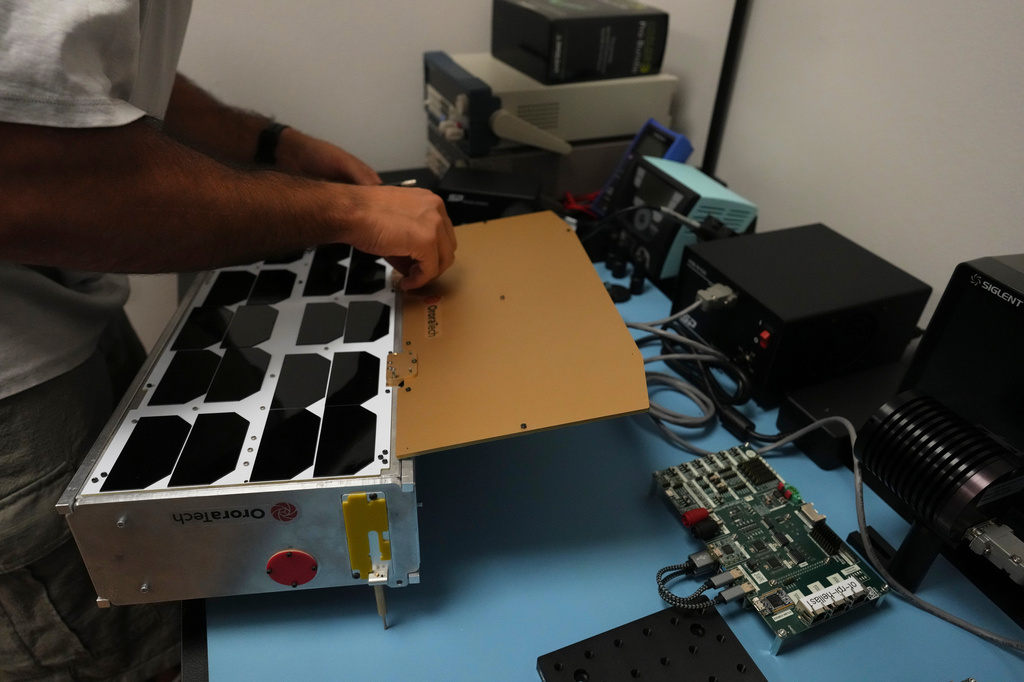 Michel Farah, an OroraTech software engineer, works on a replica of a wildfire-detection satellite at the company's facilities in Athens, Greece, on Thursday, June 18, 2026. (AP Photo/Petros Giannakouris)