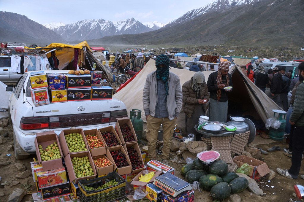 Spectators eat food from a makeshift food stall at a temporary tent village set up for three-day annual Shandur Polo Festival in Shandur Pass, in the Ghizer district of Gilgit-Baltistan, northern Pakistan, Friday, June 12, 2026. (AP Photo/Zubair Abbasi)