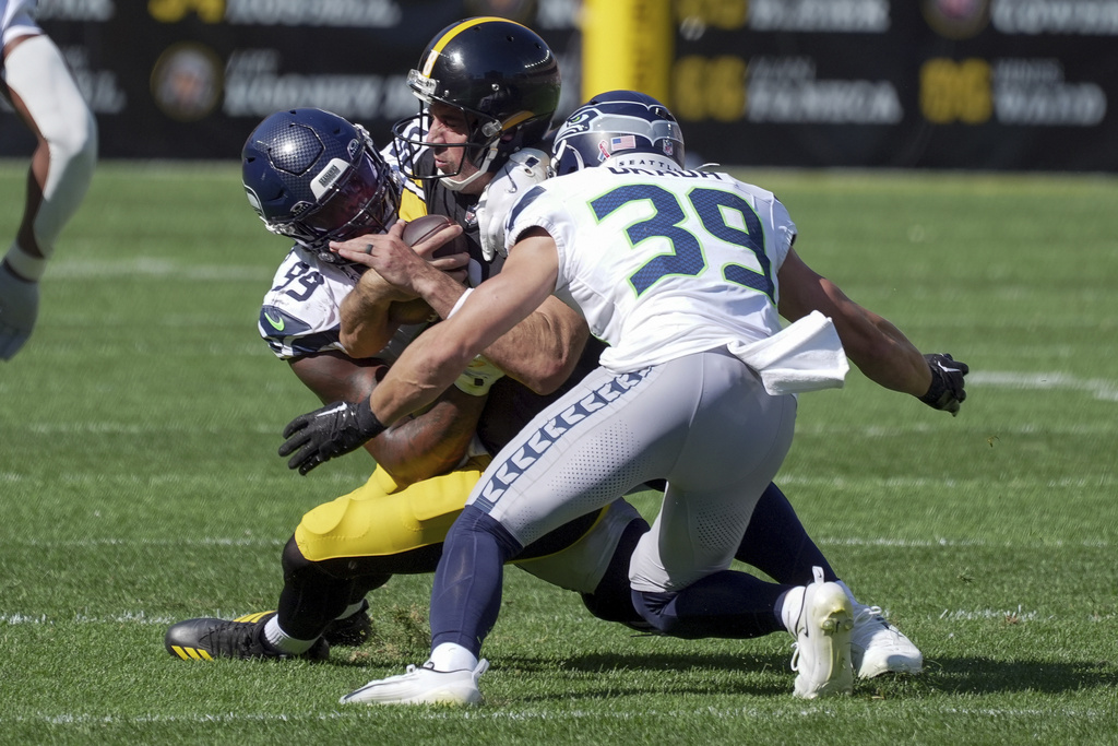 Pittsburgh Steelers quarterback Aaron Rodgers (8) is tackled by Seattle Seahawks defensive end Leonard Williams (99) and safety Ty Okada (39) during the second half of an NFL football game Sunday, Sept. 14, 2025, in Pittsburgh. (AP Photo/Gene J Puskar)