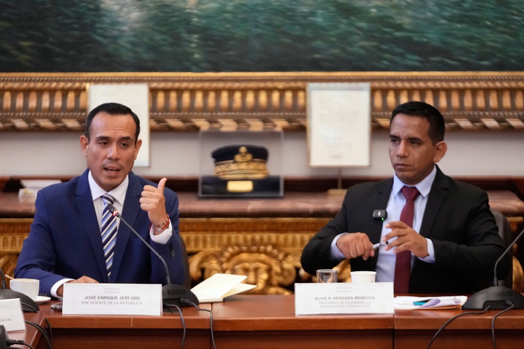 Peru's interim President Jose Jeri, left, speaks to lawmakers, next to congressman Elvis Vergara, at Congress in Lima, Peru, Wednesday, Jan. 21, 2026. (AP Photo/Martin Mejia)