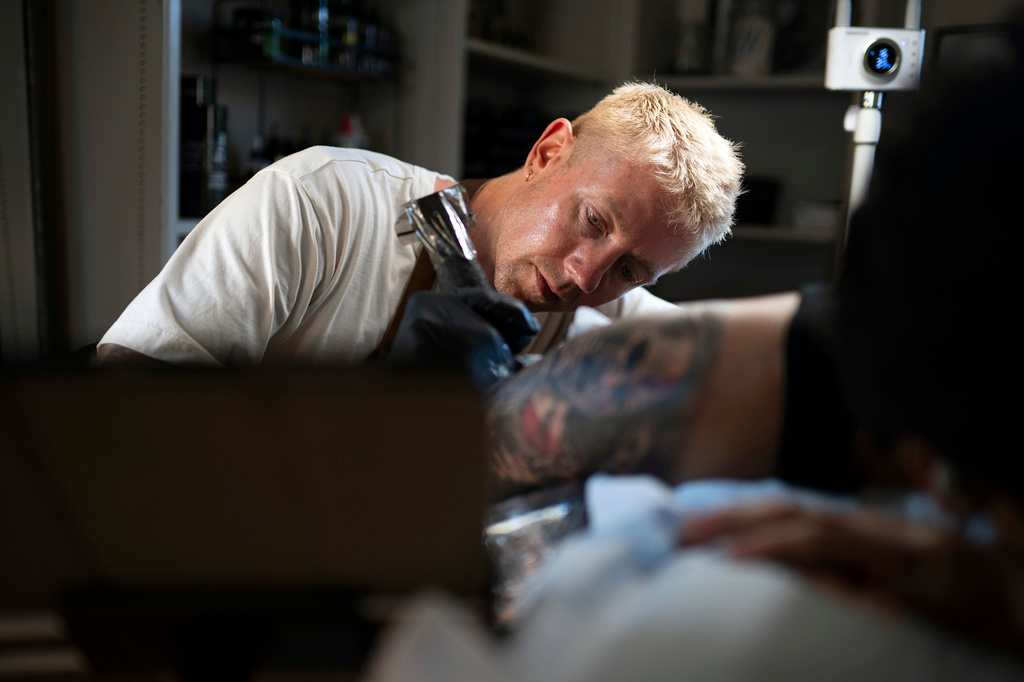 Tattoo artist Francis Palmquist works on longtime client David Gonzalez in Exton, Pa., on Tuesday, Aug. 4, 2026. (Joe Lamberti/Religion News Service via AP)