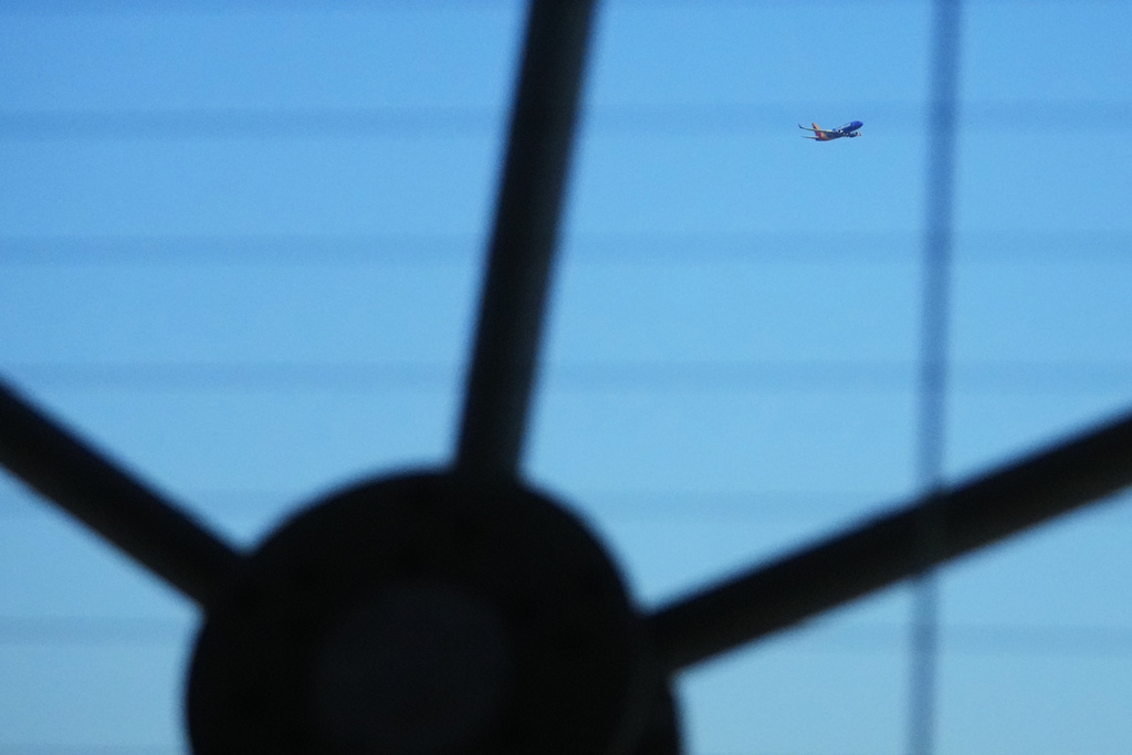 A Southwest Airlines airplane is seen through the structure at Reunion Tower as it flies over Dallas after taking off from Dallas Love Field Airport Thursday, Nov. 6, 2025. (AP Photo/Julio Cortez)
