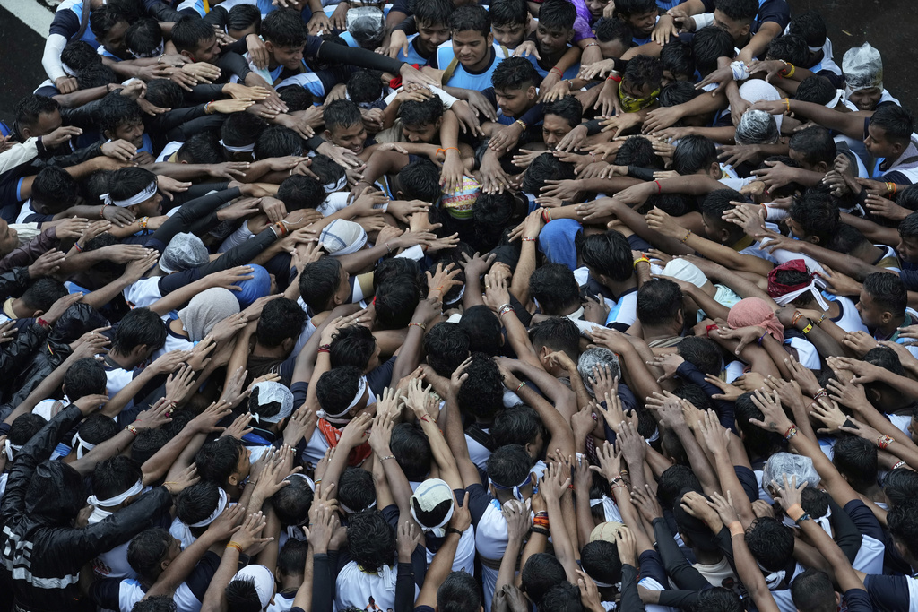 Devotees try to form a human pyramid to break a clay pot containing curd hanging above during the celebrations to mark the Hindu festival of Janmashtami in Mumbai, India, Saturday, Aug. 16, 2025. (AP Photo/Rajanish Kakade)