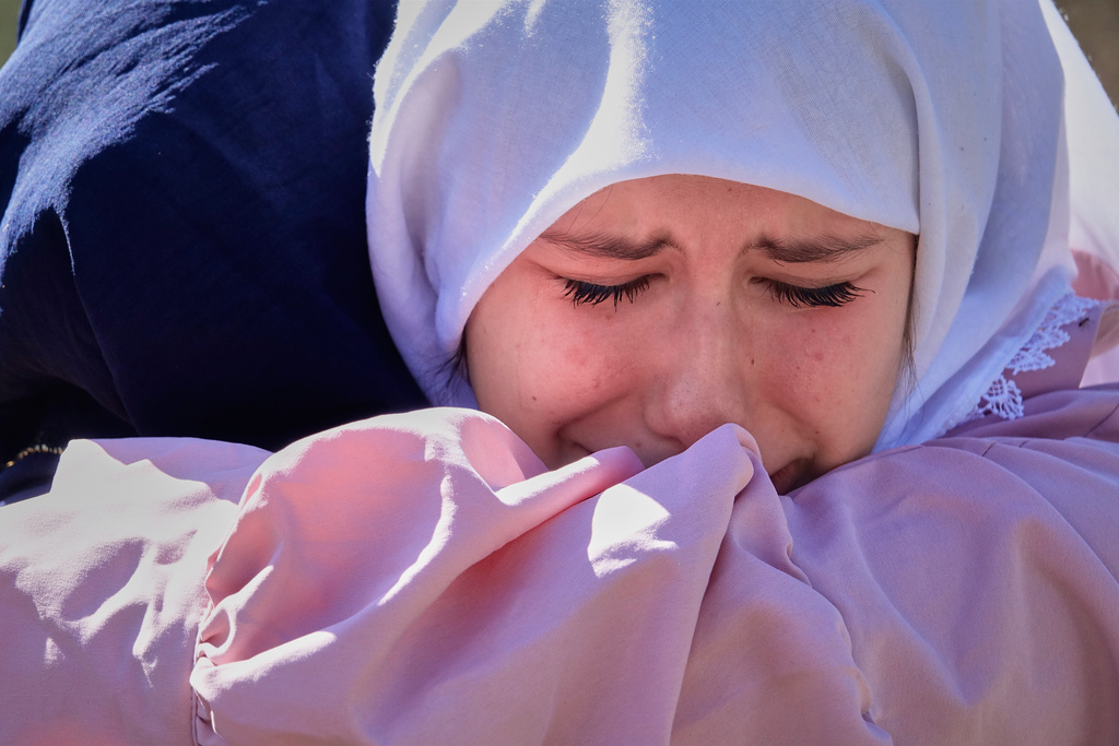 Relatives of victims weep during a memorial service, a year after floods and a landslide swept through the tiny village of Donja Jablanica in southern Bosnia, killing 19 people, Saturday, Oct. 4, 2025. (AP Photo/Eldar Emric)