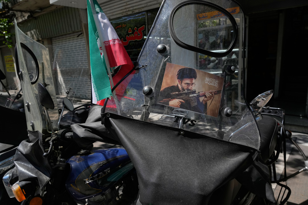 A poster is pasted on a motorbike windshield with graphic depicting Iran's Supreme Leader Ayatollah Mojtaba Khamenei as government supporters gather to mark the 40th day since the killing of his father, Supreme Leader Ayatollah Ali Khamenei, in Tehran, Iran, Thursday, April 9, 2026. (AP Photo/Vahid Salemi)