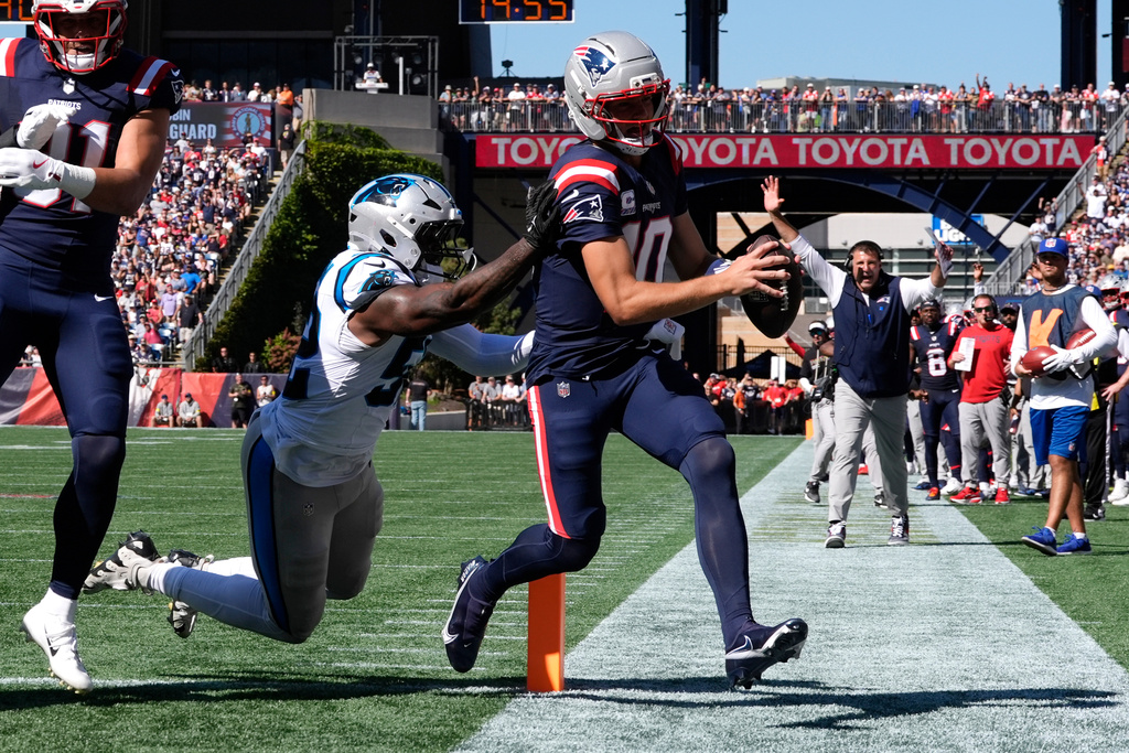 New England Patriots quarterback Drake Maye (10) scores a touchdown against Carolina Panthers linebacker DJ Johnson (52) during the first half of an NFL football game, Sunday, Sept. 28, 2025, in Foxborough, Mass. (AP Photo/Charles Krupa)