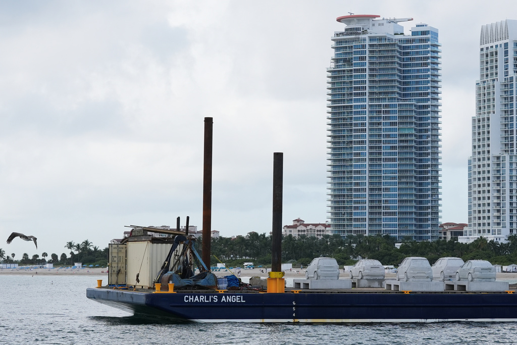 Concrete cars, which are part of a pioneering underwater sculpture park are lined up to be submerged off South Beach Tuesday, Oct. 28, 2025, in Miami Beach, Fla. (AP Photo/Marta Lavandier)