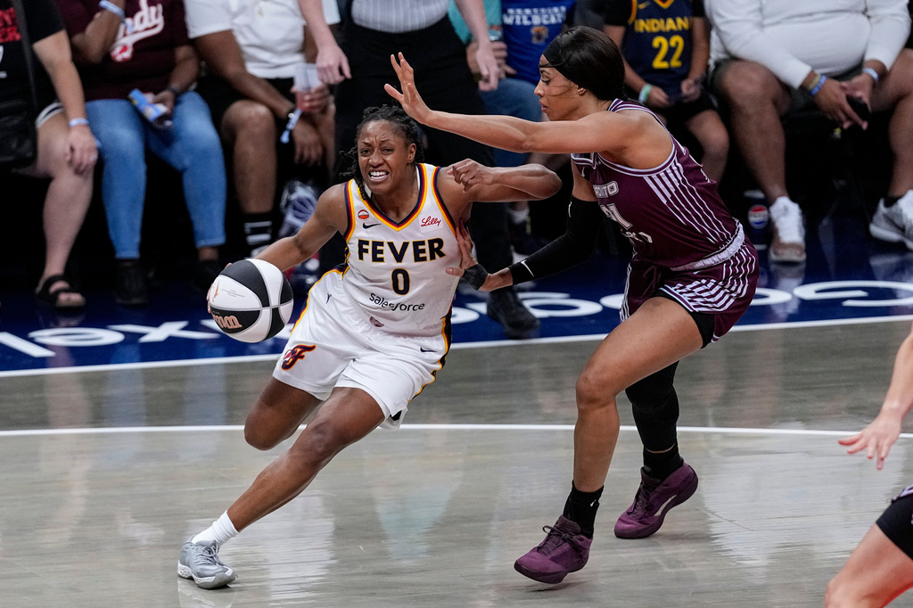 Indiana Fever guard Kelsey Mitchell (0) drives on Toronto Tempo forward Isabelle Harrison, right, in the first half of a WNBA Commissioner's Cup basketball game in Indianapolis, Tuesday, June 16, 2026. (AP Photo/Michael Conroy)