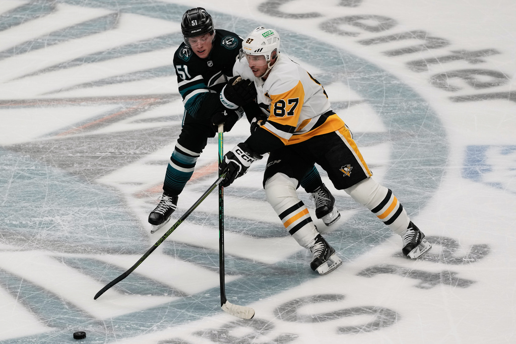 Pittsburgh Penguins center Sidney Crosby (87) skates toward the puck against San Jose Sharks right wing Collin Graf (51) during the third period of an NHL hockey game in San Jose, Calif., Saturday, Oct. 18, 2025. (AP Photo/Jeff Chiu)