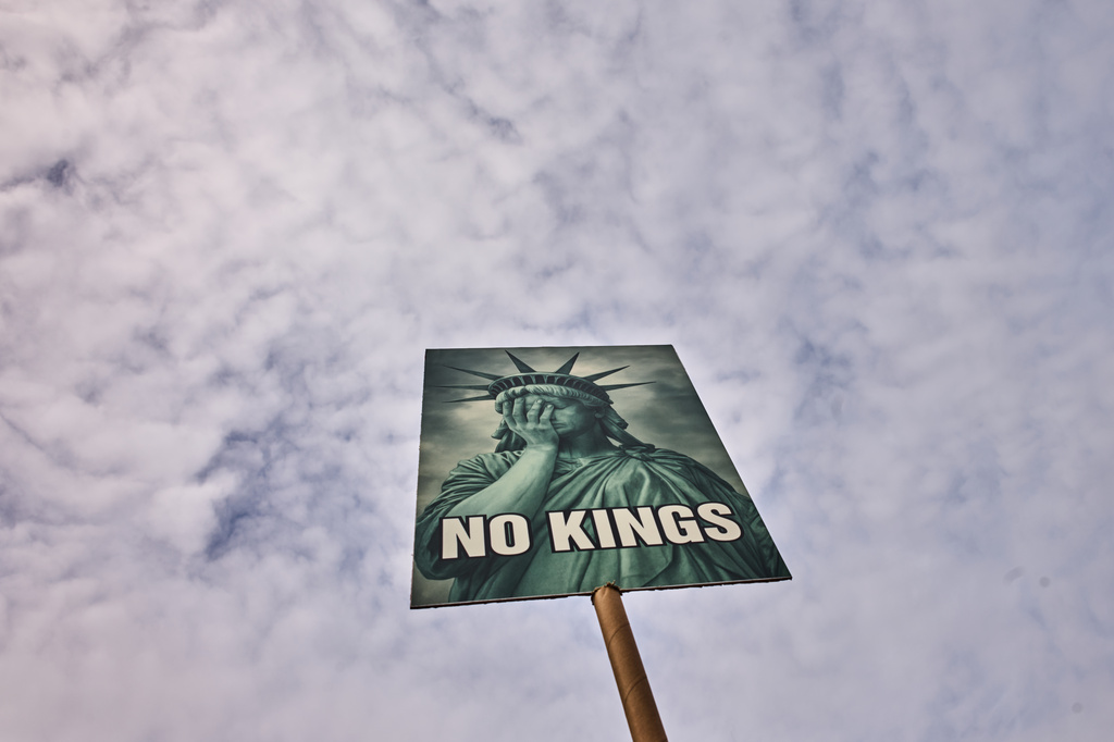 A woman shows a poster as she attends a No Kings Protest against the US government and President Donald Trump in Berlin, Germany, Saturday, March 28, 2026. (AP Photo/Markus Schreiber)