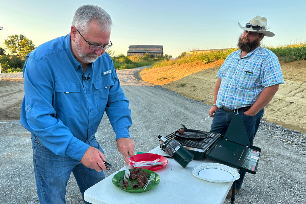 In this photo taken with a smartphone, Brent Williams, an alpha gal syndrome sufferer, prepares ostrich meat with farm owner W.D. King in Danville, Ky., on Tuesday, Aug. 18, 2026. (AP Photo/Dylan Lovan)