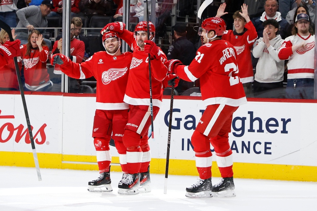 Detroit Red Wings right wing Alex DeBrincat, left, celebrates with center Dylan Larkin, center, and left wing James van Riemsdyk after scoring against the San Jose Sharks during the first period of an NHL hockey game, Friday, Jan. 16, 2026, in Detroit. (AP Photo/Duane Burleson)