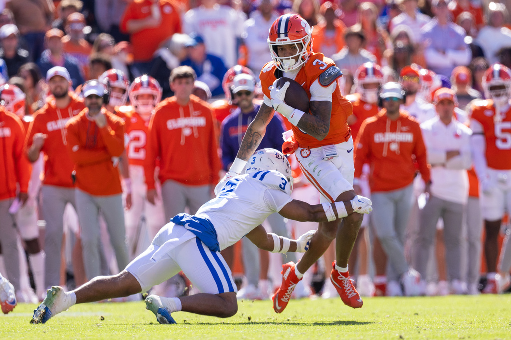 FILE - Duke defensive back Caleb Weaver (3) grabs Clemson wide receiver Tristan Smith (3) during the second half of an NCAA college football game, Saturday, Nov. 1, 2025, in Clemson, S.C. (AP Photo/Scott Kinser,File)