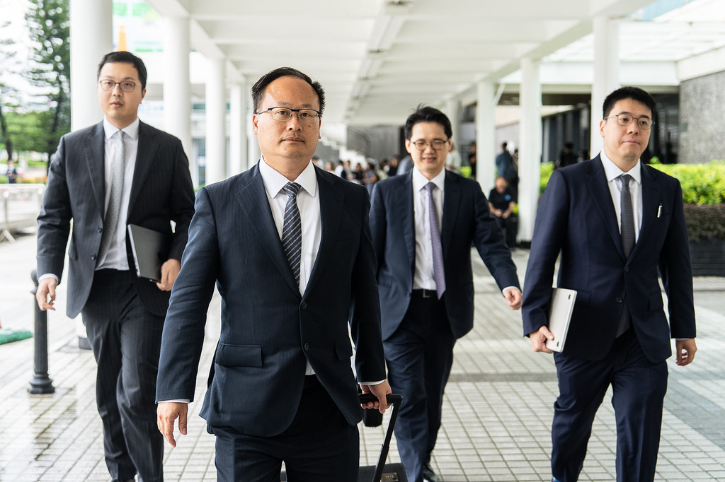 Jenkin Suen, second from left, lawyer for the government, leaves following the independent committee hearing investigating last year's Tai Po deadly fire in Hong Kong, Wednesday, July 15, 2026. (AP Photo/Chan Long Hei)
