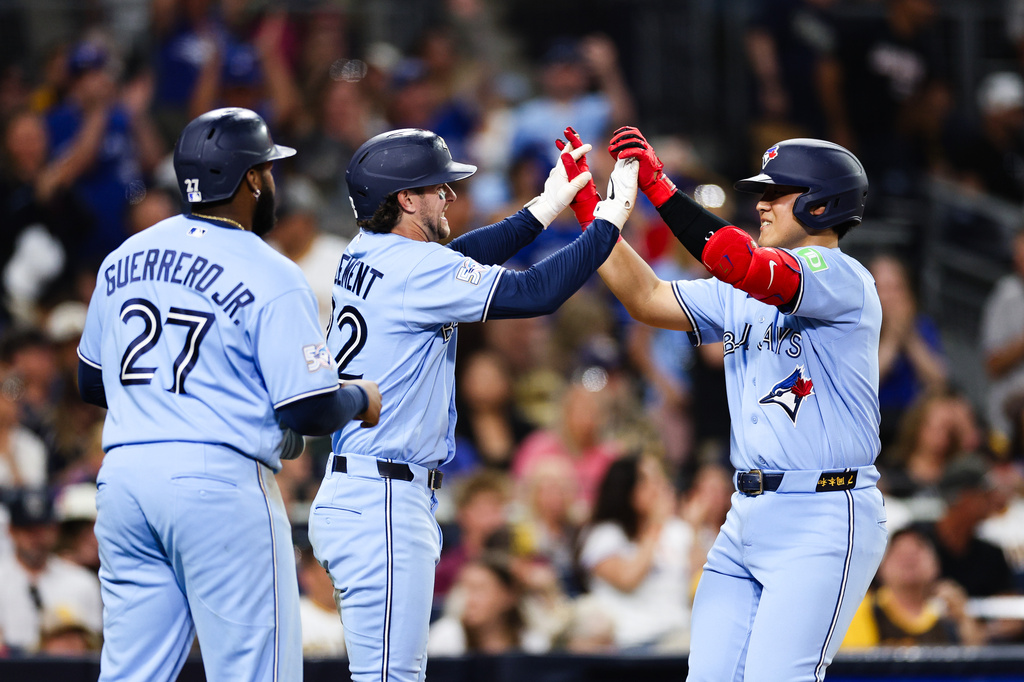 Toronto Blue Jays' Kazuma Okamoto, right, is congratulated by Ernie Clement, center, as Vladimir Guerrero Jr., left, looks on after Okamoto hit a three-run home run against the San Diego Padres in the fifth inning of a baseball game Friday, July 10, 2026, in San Diego. (AP Photo/Derrick Tuskan)
