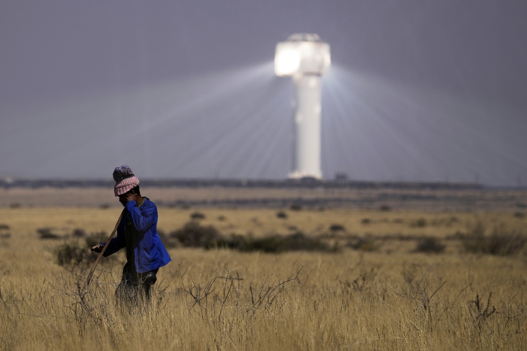 A shepherd watches livestock near Khi Solar One, a solar thermal plant that converts the sun's light energy into electricity, outside Upington, South Africa, in the Northern Cape province, Friday, Aug. 29, 2025. (AP Photo/Themba Hadebe)
