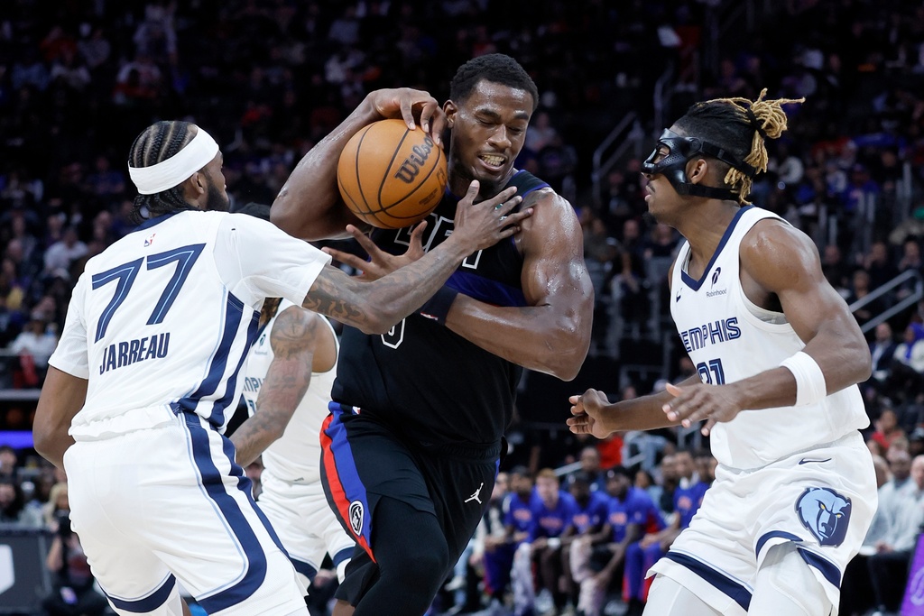 Detroit Pistons center Jalen Duren, center, drives to the basket against Memphis Grizzlies guards DeJon Jarreau (77) and Jahmai Mashack, right, during the second half of an NBA basketball game Friday, March 13, 2026, in Detroit. (AP Photo/Duane Burleson)