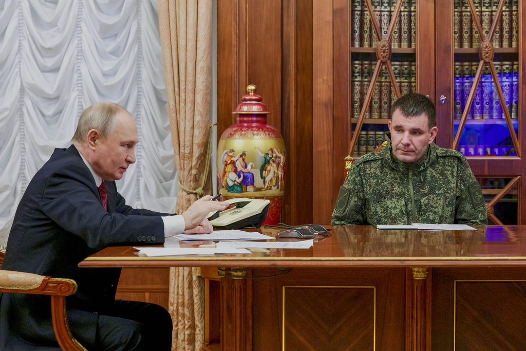Russian President Vladimir Putin, left, holds a call with military leaders on the Ukraine battlefield situation together with Denis Pirogov, right, a Russian army brigade commander, at the Kremlin in Moscow, on Thursday, Dec. 11, 2025. (Gavriil Grigorov, Sputnik, Kremlin Pool Photo via AP)