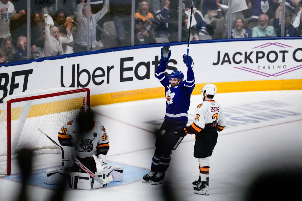 Toronto Marlies' Logan Shaw (11) celebrates after a goal by his teammate Toronto Marlies centre Vinni Lettieri (71) on the Chicago Wolves during the second period in Game 5 of the AHL hockey Calder Cup final in Toronto, Friday, June 19, 2026. (Arlyn McAdorey/The Canadian Press via AP)