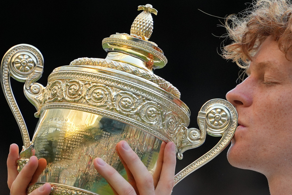 Jannik Sinner of Italy kisses the winners trophy after defeating Alexander Zverev of Germany in the men's singles final at Wimbledon Tennis Championships in London, Sunday, July 12, 2026. (AP Photo/Kin Cheung)