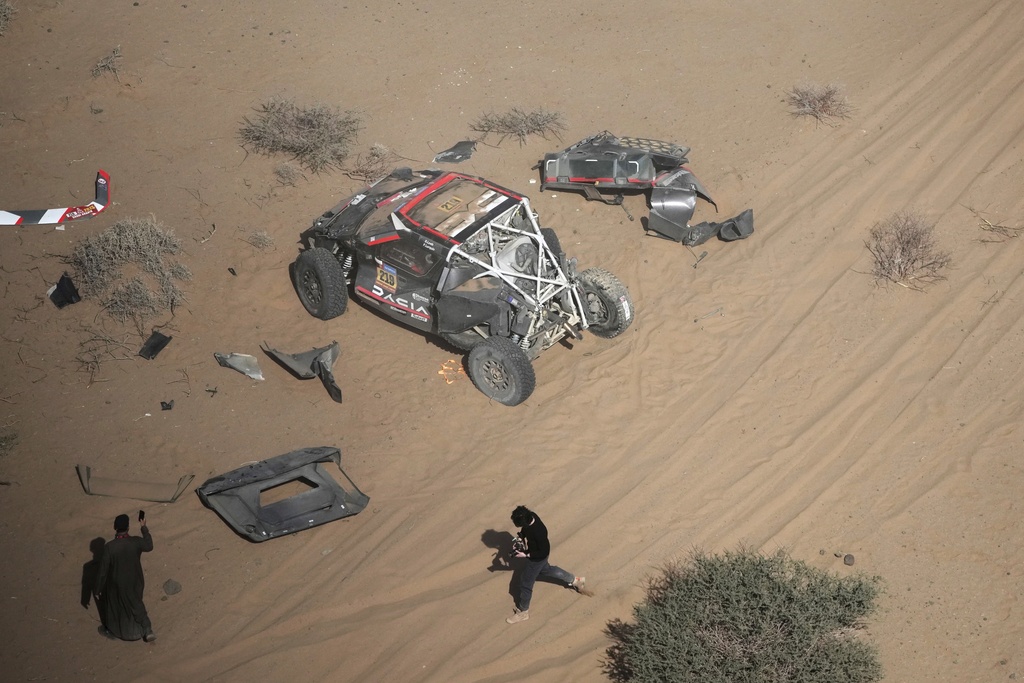 The car of driver Sebastien Loeb and co-driver Fabian Lurquin is stopped after a crash during the third stage of the Dakar Rally between Bisha and Al-Henakiyah, Saudi Arabia, Tuesday, Jan. 7, 2025. (AP Photo/Christophe Ena)