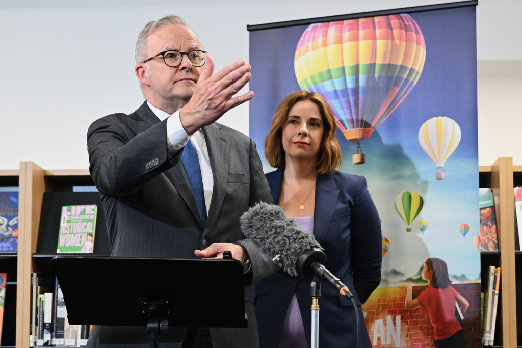 Australian Prime Minister Anthony Albanese, left, and Australian Communications Minister Anika Wells speak to the media during a visit to St John Paul II College in Canberra, Australia, on Dec. 11, 2025. (Lukas Coch/AAP Image via AP)
