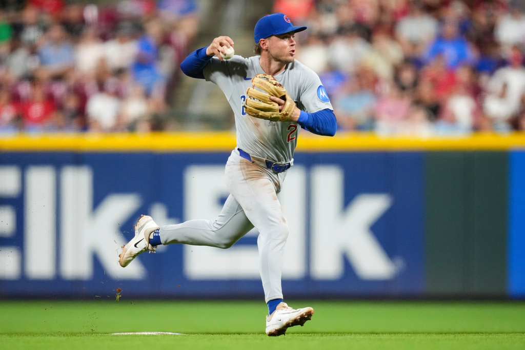 FILE- Chicago Cubs second baseman Nico Hoerner fails to throw out Cincinnati Reds' Austin Hays at first base during the sixth inning of a baseball game, Friday, Sept. 19, 2025, in Cincinnati. (AP Photo/Jeff Dean, File)
