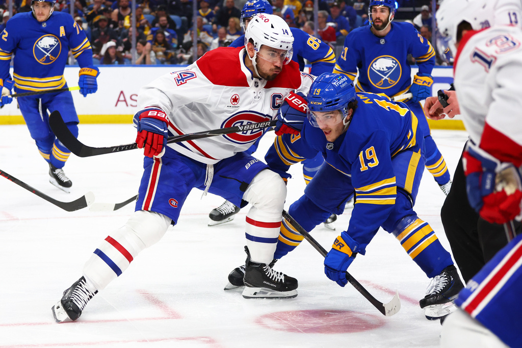Montreal Canadiens center Nick Suzuki, front left, and Buffalo Sabres center Peyton Krebs (19) battle after a face-off during the second period in Game 1 of a second-round NHL hockey Stanley Cup playoff series, Wednesday, May 6, 2026, in Buffalo, N.Y. (AP Photo/Jeffrey T. Barnes)