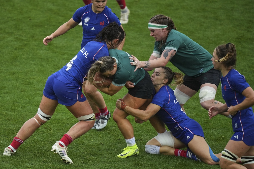 Ireland's Aoife Dalton, center, is tackled by France's captain Mane Feleu, left, and her teammate Joanna Grisez during a Women's Rugby World Cup 2025 quarterfinal match between France and Ireland, in Exeter, England, Sunday, Sept. 14, 2025. (AP Photo/Alastair Grant)