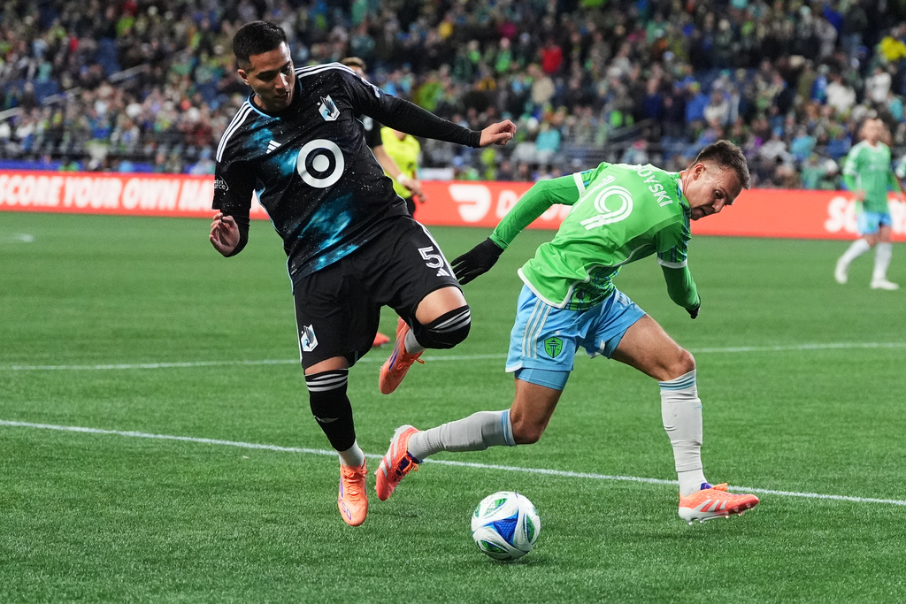 Minnesota United defender Nicolás Romero (5) is able to clear the ball from Seattle Sounders forward Danny Musovski (19) during the first half of Game 2 in the first round of MLS soccer's Western Conference playoffs Monday, Nov. 3, 2025, in Seattle. (AP Photo/Lindsey Wasson)