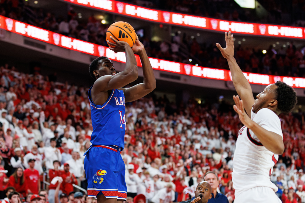Kansas's Melvin Council Jr. (14) attempts a three-pointer over North Carolina State's Quadir Copeland during the second half of an NCAA college basketball game in Raleigh, N.C., Saturday, Dec. 13, 2025. (AP Photo/Ben McKeown)