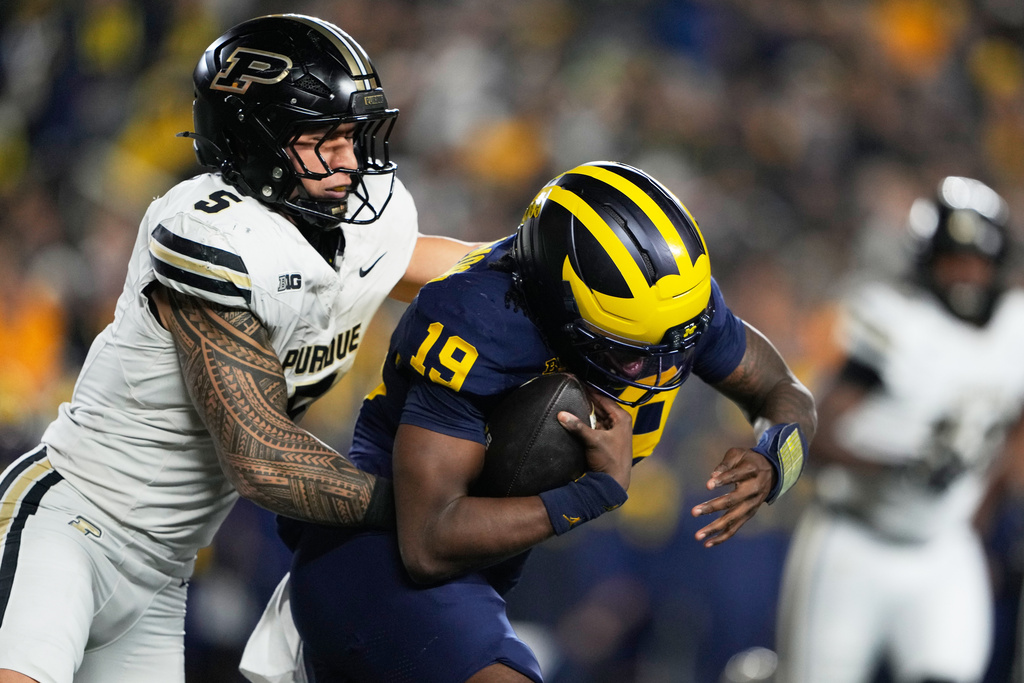 Michigan quarterback Bryce Underwood, right, is tackled by Purdue linebacker Charles Correa during the first half of an NCAA college football game against Purdue, Saturday, Nov. 1, 2025, in Ann Arbor, Mich. (AP Photo/Ryan Sun)