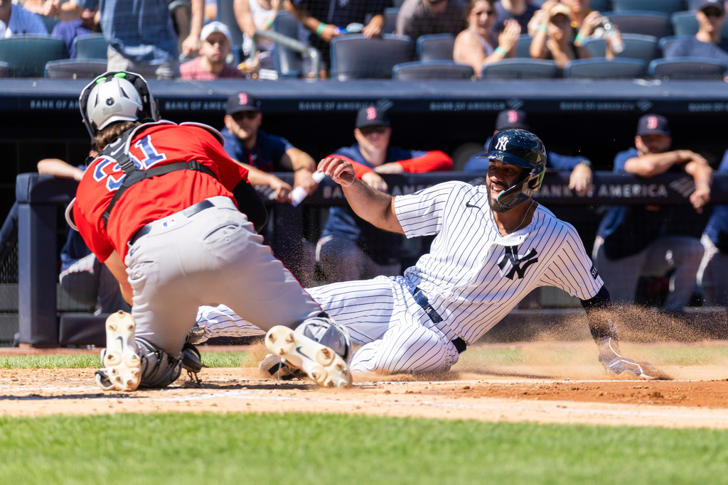 Boston Red Sox catcher Adley Rutschman (31) tags out New York Yankees' Amed Rosario (14) at home as he tries to score on a double hit by Heliot Ramos (34) in the fourth inning during the first baseball game of a doubleheader, Saturday, Aug. 29, 2026, in New York. (AP Photo/Corey Sipkin)