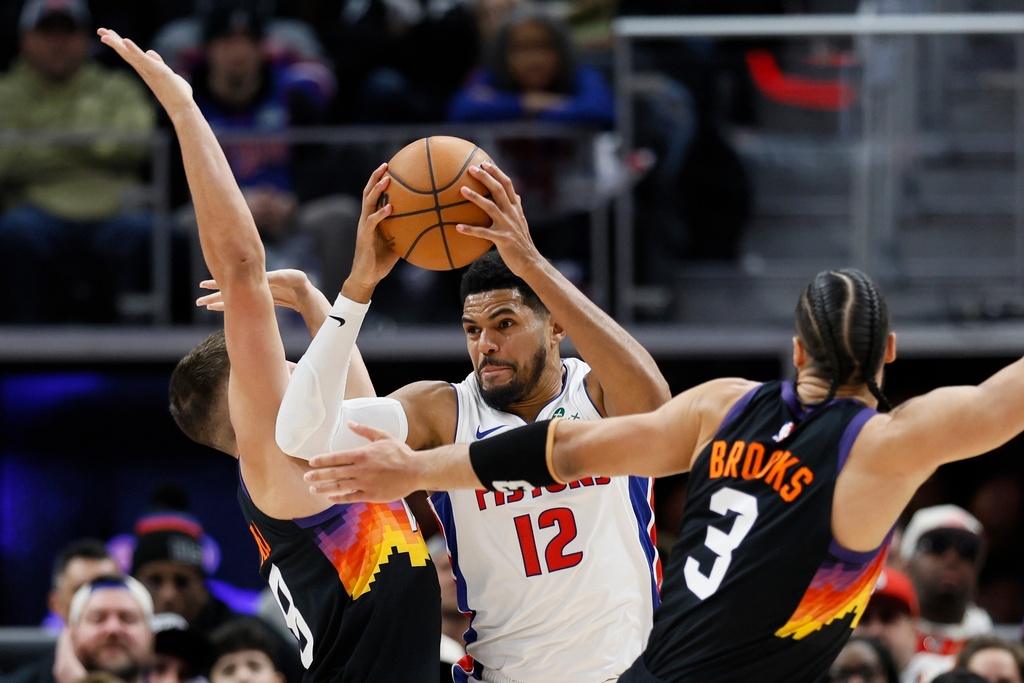 Detroit Pistons forward Tobias Harris (12) tries going to the basket against Phoenix Suns guard Grayson Allen, left, and forward Dillon Brooks (3) during the first half of an NBA basketball game, Thursday, Jan. 15, 2026, in Detroit. (AP Photo/Duane Burleson)