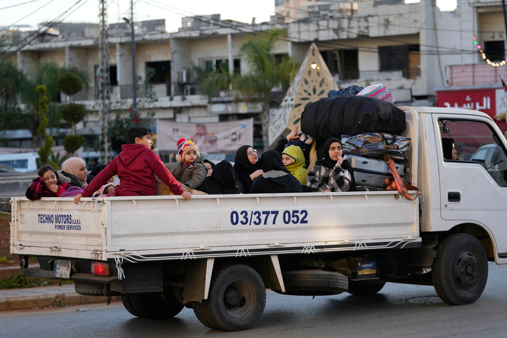 Displaced people fleeing Israeli airstrikes in southern Lebanon ride on a mini truck along a highway toward Beirut, in the southern port city of Sidon, Lebanon, Monday, March 2, 2026. (AP Photo/Mohammed Zaatari)