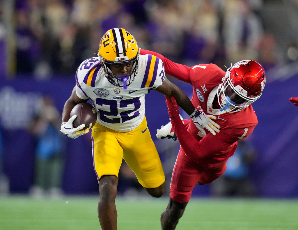 Houston defensive back Latrell McCutchin Sr. (1) tries to stop LSU running back Harlem Berry (22) during the first half of the Kinder's Texas Bowl NCAA football game, Saturday, Dec. 27, 2025, in Houston. (AP Photo/Karen Warren)