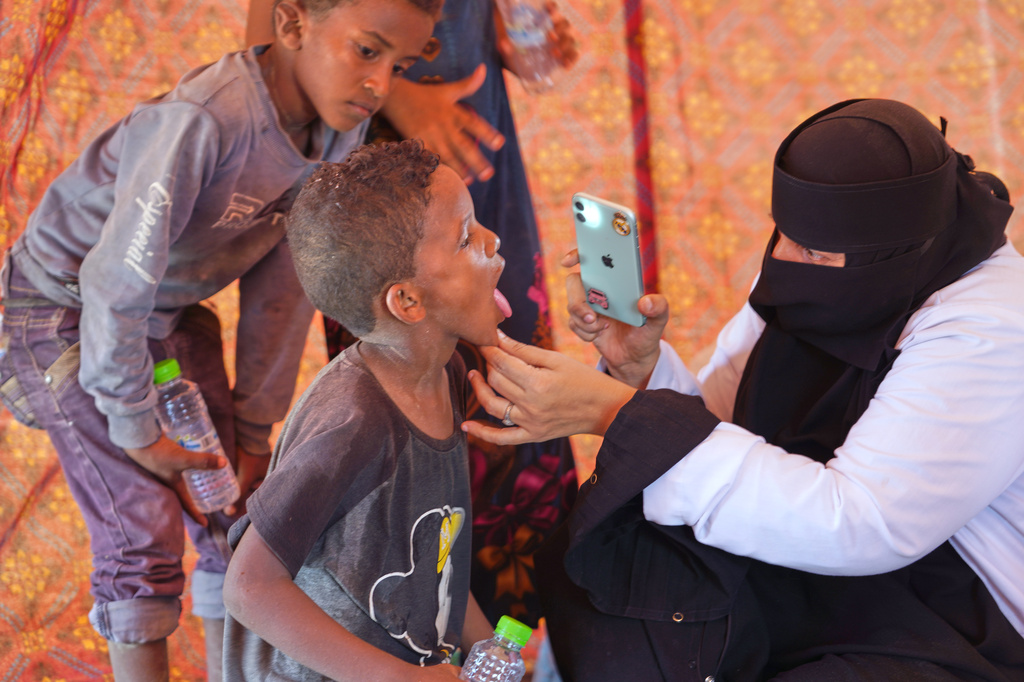 A doctor examines a displaced child at Al-Firdaws camp in Ras Imran, just outside Aden, Yemen, Monday, Sept. 14, 2026. (AP Photo/Abdulnasser Alseddik)