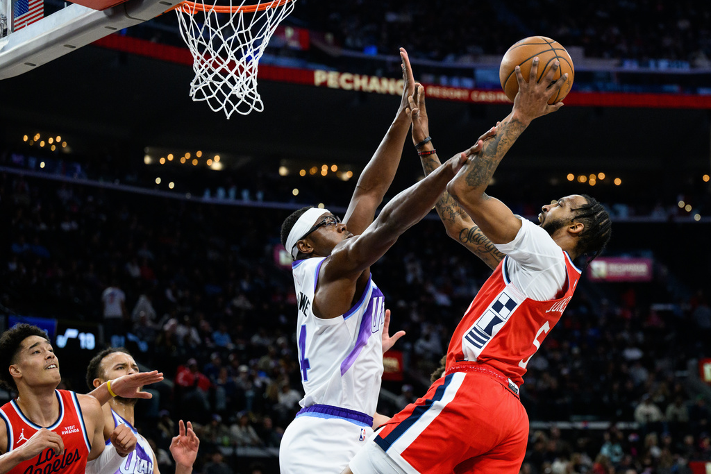 Los Angeles Clippers forward Derrick Jones Jr., right, shoots while while under pressure from Utah Jazz center Oscar Tshiebwe, center, during the first half of an NBA basketball game Thursday, Jan. 1, 2026, in Inglewood, Calif. (AP Photo/William Liang)