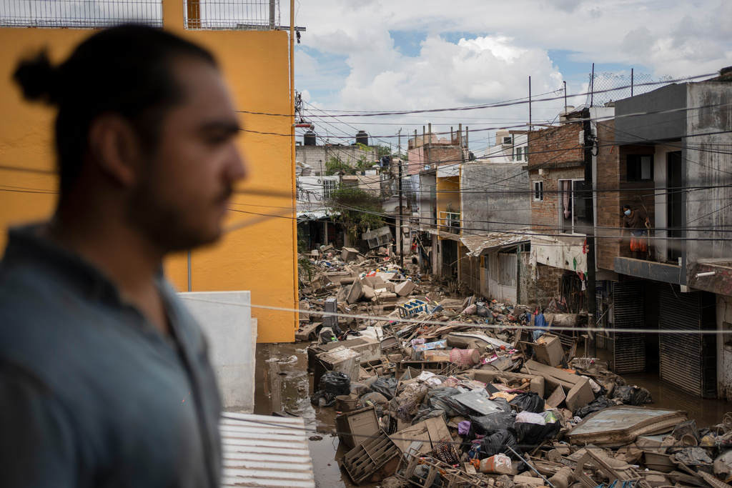 Debris lies in the street as a man looks on from a damaged house in Poza Rica, Veracruz state, Mexico, Wednesday, Oct. 15, 2025, after deadly floods and torrential rain. (AP Photo/Felix Marquez)