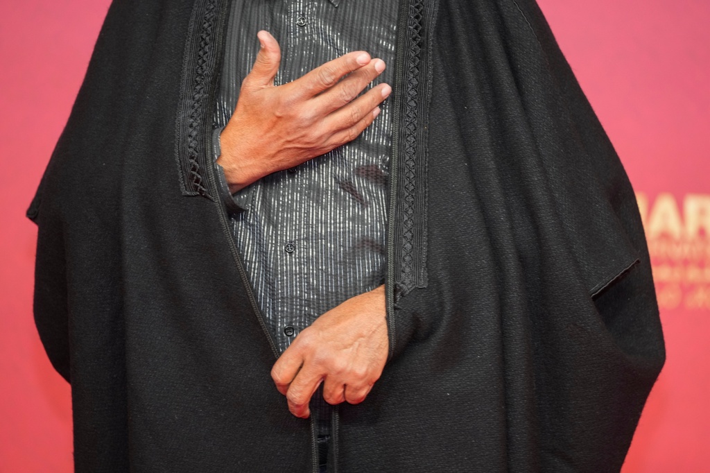 A moroccan actor poses for a photo wearing a traditional outfit on the red carpet during the opening ceremony of the 22nd Marrakech Film Festival, in Morocco, Friday, Nov. 28, 2025. (AP Photo/Mosa'ab Elshamy)