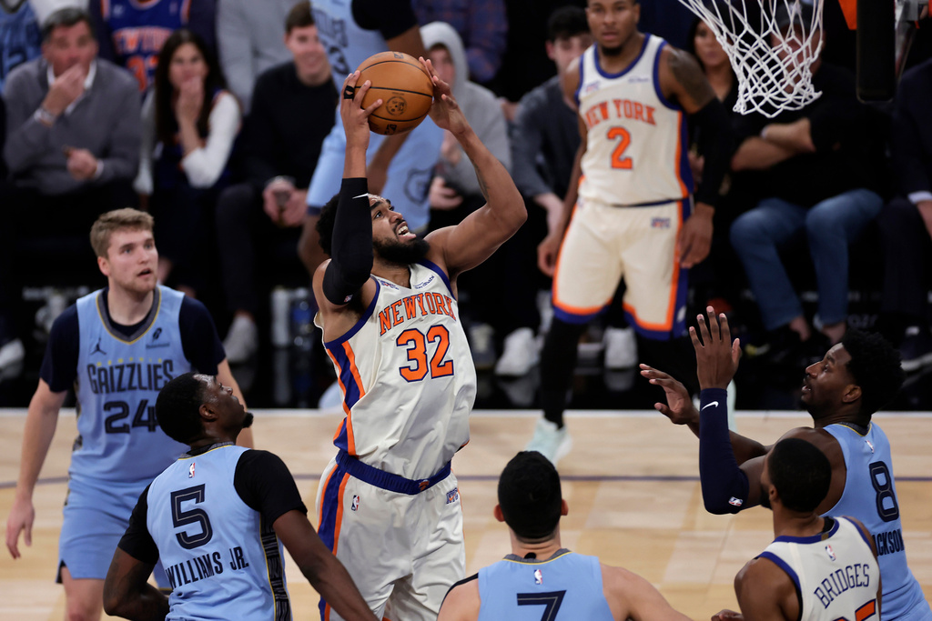 New York Knicks center Karl-Anthony Towns (32) shoots over Memphis Grizzlies forward Jaren Jackson Jr. (8) during the first half of an NBA basketball game, Tuesday, Nov. 11, 2025, in New York. (AP Photo/Adam Hunger)